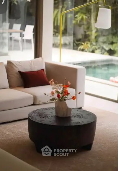Luxurious living room with pool view, modern furniture, and elegant decor.
