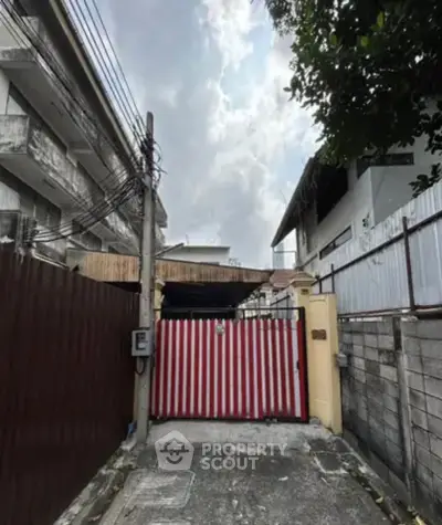Charming urban property with gated entrance and potential for renovation in a bustling neighborhood.