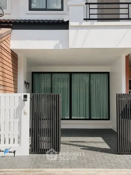 Modern townhouse exterior with sleek black gate and large windows