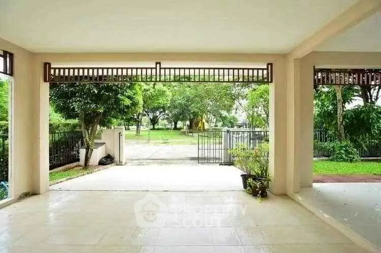 Spacious covered patio with garden view in serene residential area.