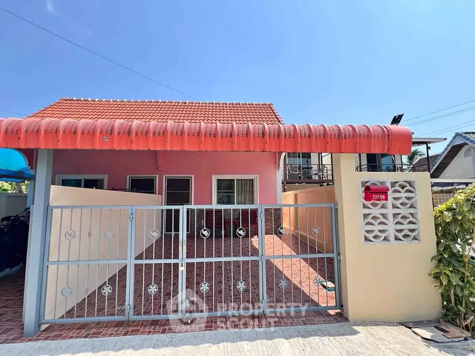 Charming single-story home with red-tiled roof and gated entrance, perfect for cozy living.