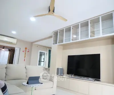 Modern living room with sleek entertainment center and cozy sectional sofa.