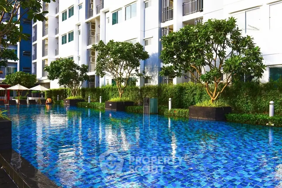 Luxurious apartment complex with stunning outdoor pool and lush greenery.