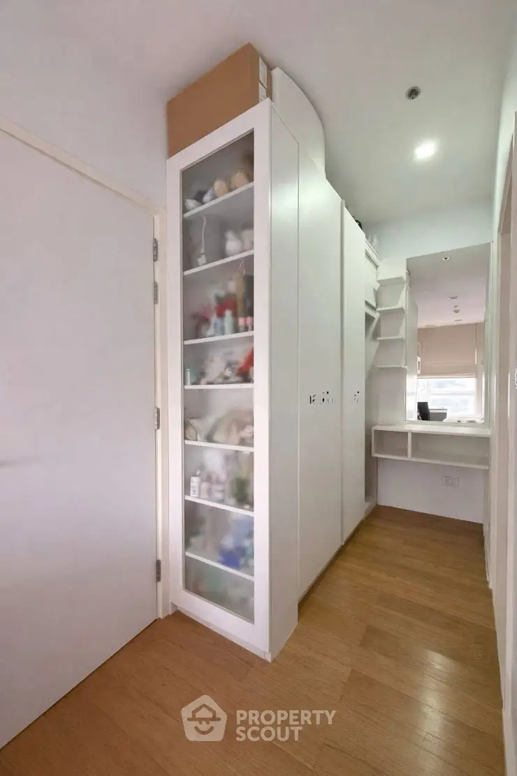 Modern storage area with sleek white cabinets and wooden flooring