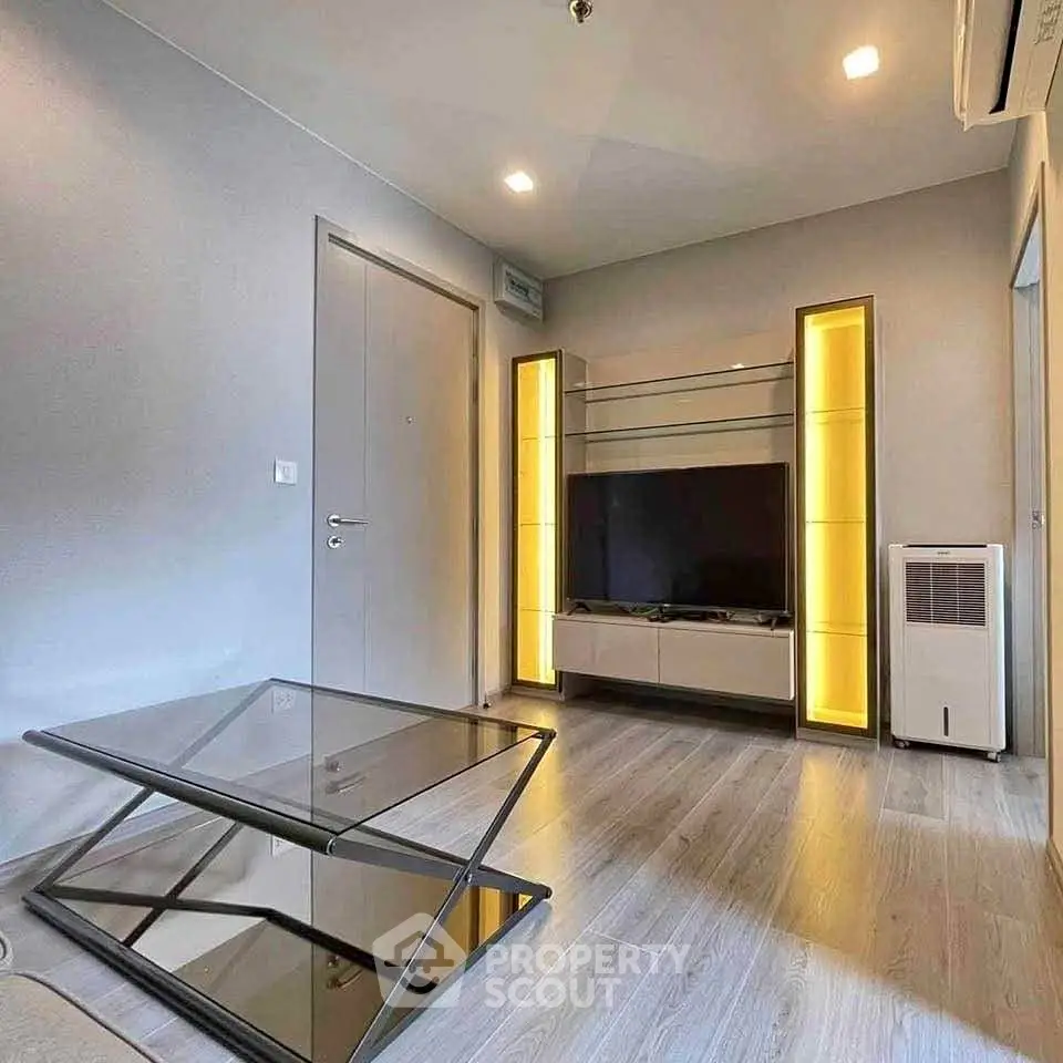 Modern living room with sleek glass table and illuminated shelving, perfect for contemporary urban living.