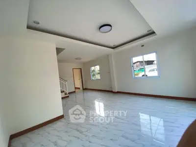 Spacious and bright living room with modern tile flooring and large windows.