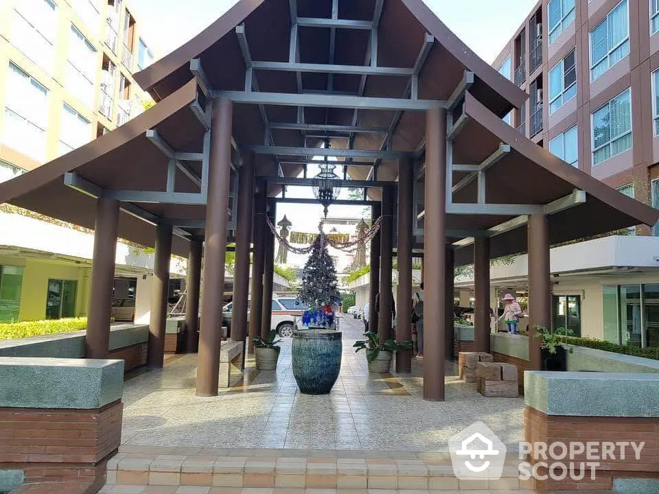 Stunning entrance of modern residential building with unique architectural design and lush greenery.