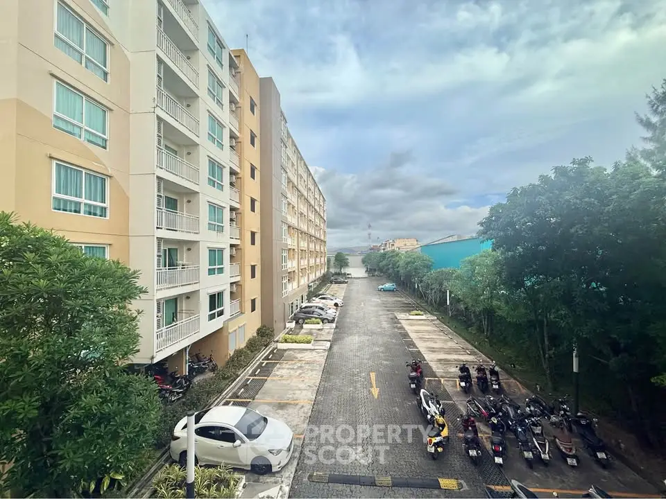 Spacious apartment building with ample parking and lush greenery, offering a serene living environment.