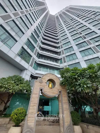 Stunning high-rise building entrance with modern architecture and lush greenery