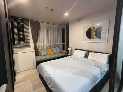 Modern bedroom with cozy decor and stylish artwork, featuring a comfortable bed and seating area.