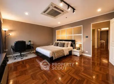 Spacious bedroom with elegant wooden flooring and modern decor