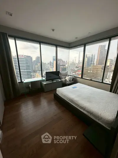 Luxurious bedroom with stunning city view and modern furnishings in high-rise apartment.