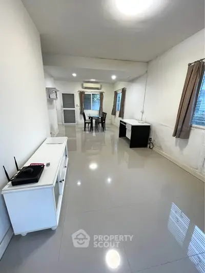 Spacious living room with modern furniture and natural light, perfect for relaxation and entertainment.