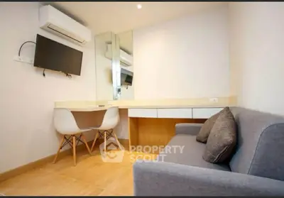 Modern study room with sleek desk, wall-mounted TV, and cozy sofa in a stylish apartment.