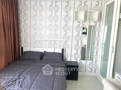 Modern bedroom with stylish wallpaper and sleek furnishings in a cozy apartment.