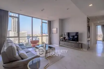 Luxurious living room with stunning city view, modern furniture, and floor-to-ceiling windows in high-rise apartment.