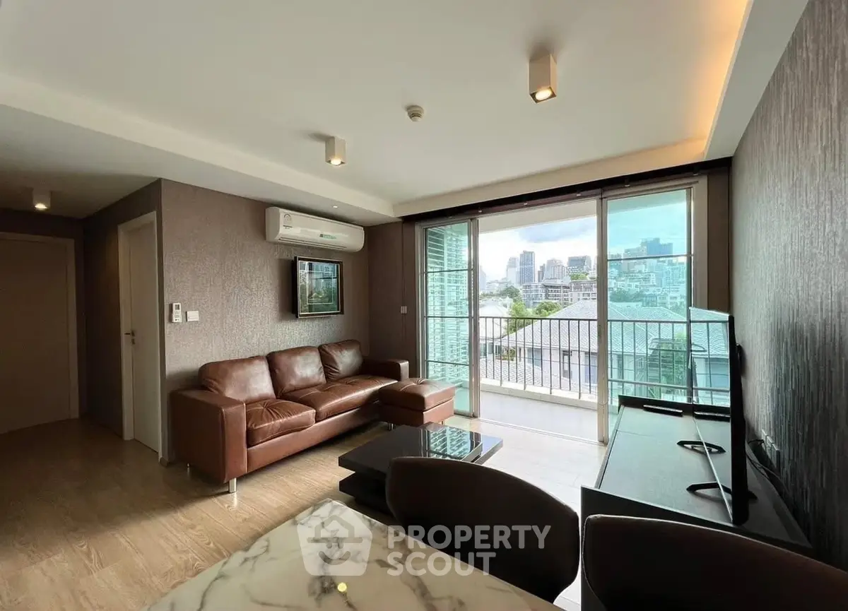 Modern living room with city view and stylish furniture in a high-rise apartment.