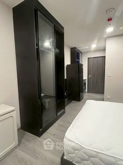 Modern bedroom with sleek black wardrobe and minimalist design