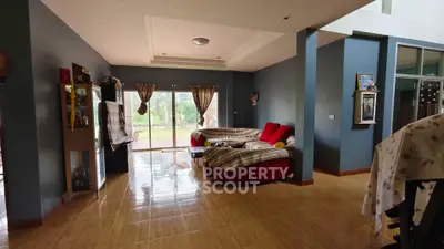Spacious living room with modern decor and large windows offering garden views.
