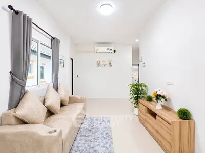 Modern living room with beige sofa, stylish decor, and natural light.