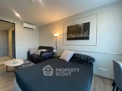 Modern bedroom with stylish decor and cozy seating area in a contemporary apartment.
