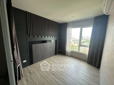 Modern empty room with large window and city view, featuring sleek flooring and stylish wall design.
