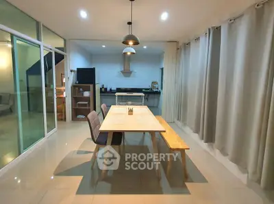 Modern dining area with sleek kitchen, open layout, and stylish lighting