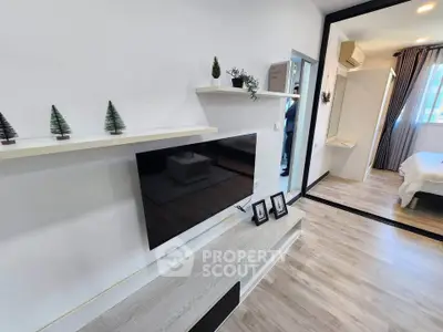 Modern living room with sleek TV setup and cozy bedroom view
