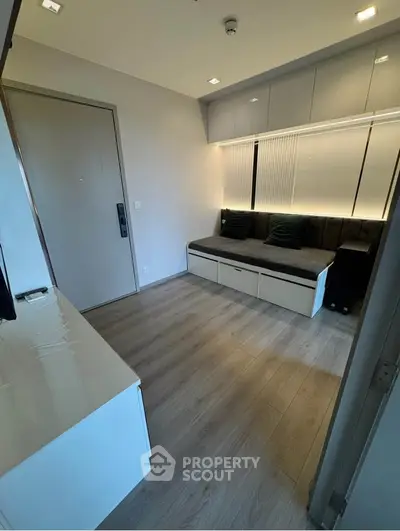 Modern compact living room with sleek storage solutions and cozy seating.