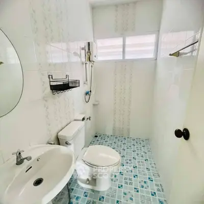 Compact bathroom with modern fixtures and patterned tile flooring.