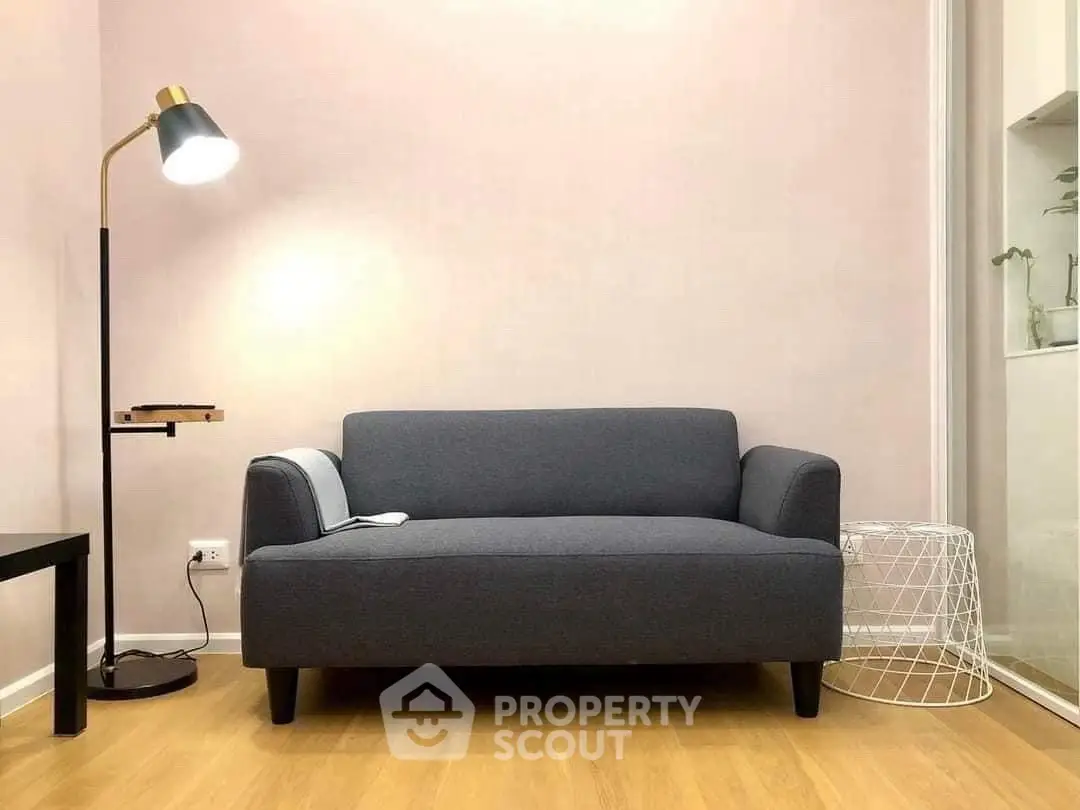 Modern living room with stylish gray sofa and elegant floor lamp on wooden flooring.