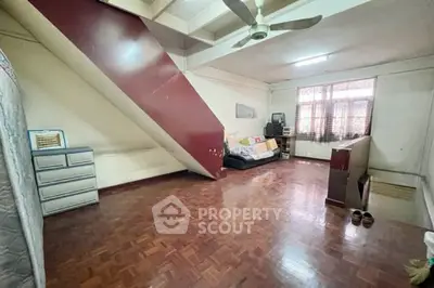 Spacious loft-style room with wooden flooring and modern ceiling fan