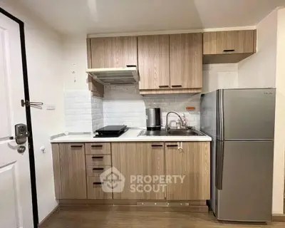 Modern compact kitchen with sleek wooden cabinets and stainless steel appliances