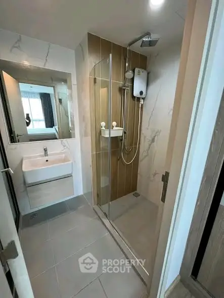 Modern bathroom with glass shower and sleek fixtures in a contemporary apartment.