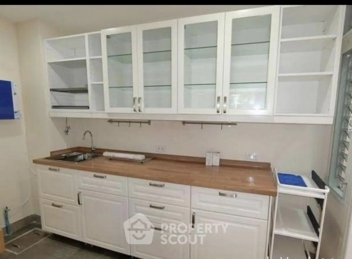 Modern kitchen with white cabinets and wooden countertop
