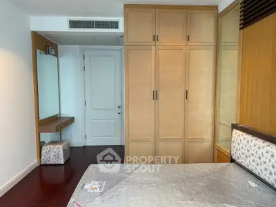Spacious bedroom with built-in wardrobe and elegant wooden flooring