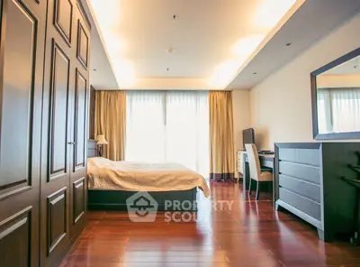 Spacious bedroom with wooden flooring and modern furnishings