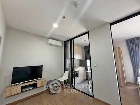 Modern living room with open kitchen and sleek design in a stylish apartment.