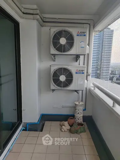 Spacious balcony with air conditioning units and city view