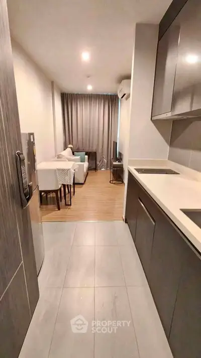 Modern open-layout kitchen and living room with sleek design and cozy ambiance.