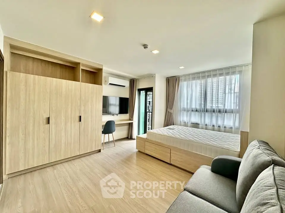 Spacious modern bedroom with large windows and stylish furniture in a high-rise apartment.