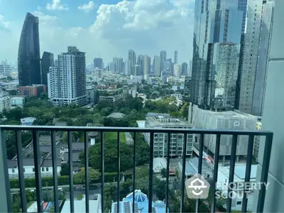 Stunning cityscape view from a high-rise balcony overlooking urban skyline and lush greenery.