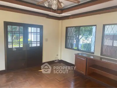 Spacious living room with wooden floors and large windows for natural light