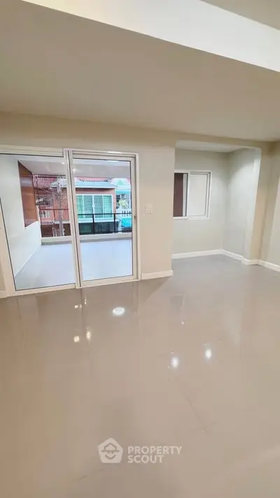 Spacious modern living room with large sliding doors to balcony