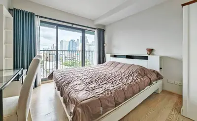 Spacious bedroom with city view and modern furnishings in urban apartment
