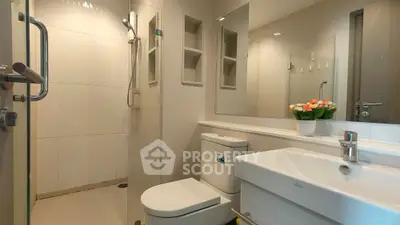Modern bathroom with sleek fixtures and elegant design, featuring a glass shower and stylish vanity.