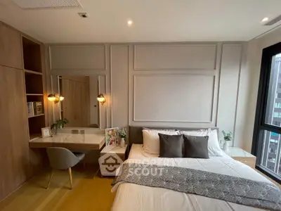 Modern bedroom with stylish decor, large window, and cozy workspace in a contemporary apartment.