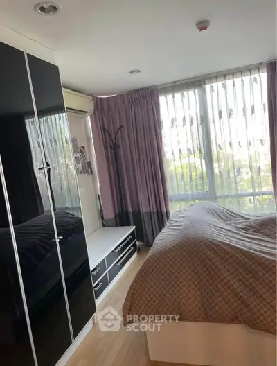 Cozy bedroom with large window and modern black wardrobe