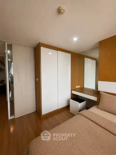 Modern bedroom with sleek design and ample storage in a cozy apartment.