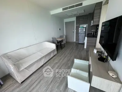Modern living room with sleek furniture and open kitchen layout in a stylish apartment.